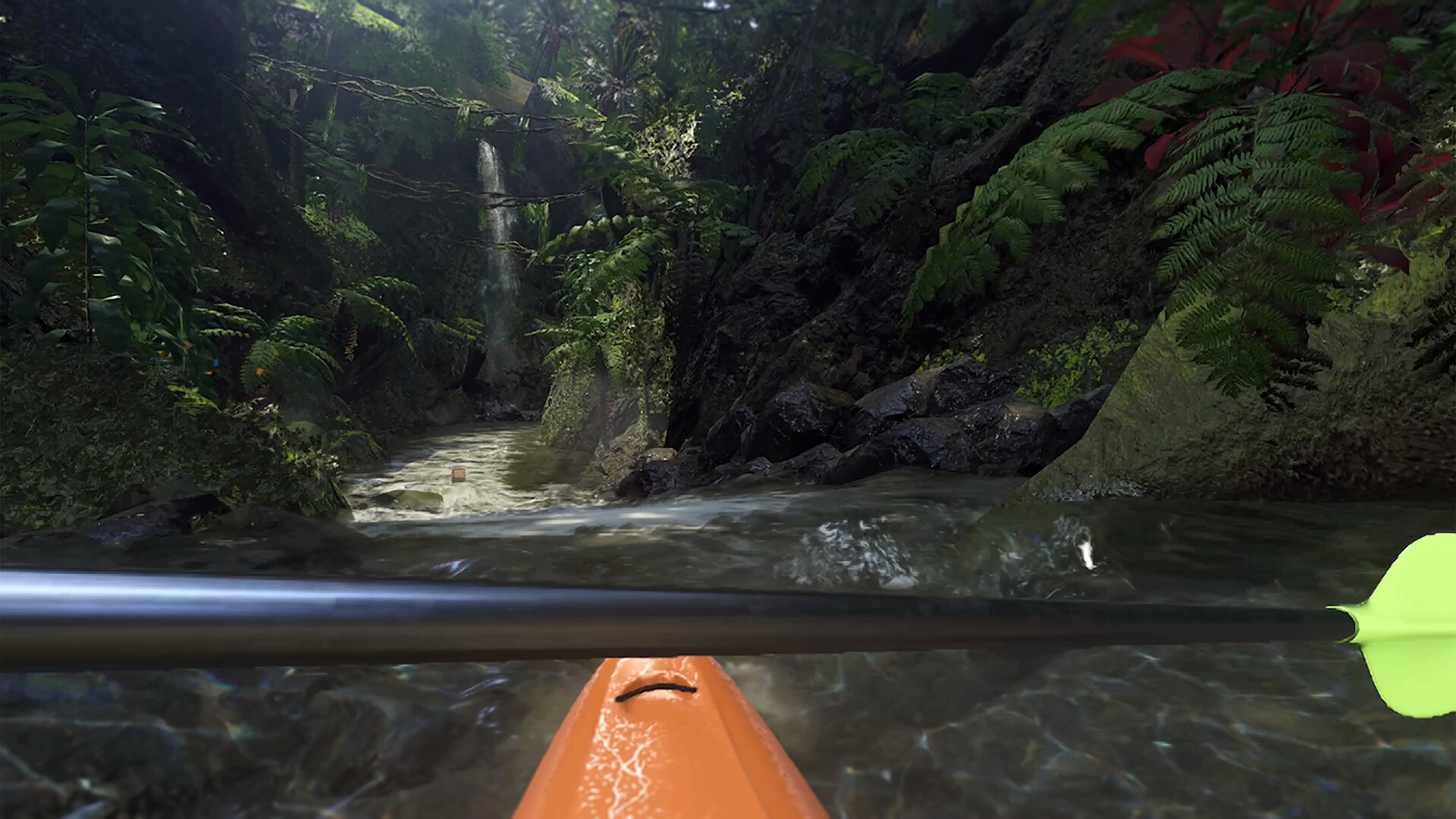 A tropical waterway with a waterfall ahead, walls of foliage, and the paddle and bow of a kayak facing downstream